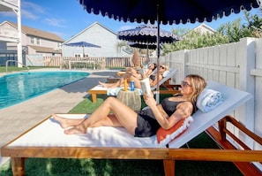 Un espace aménagé au bord de la piscine, avec des chaises longues et des parasols.
