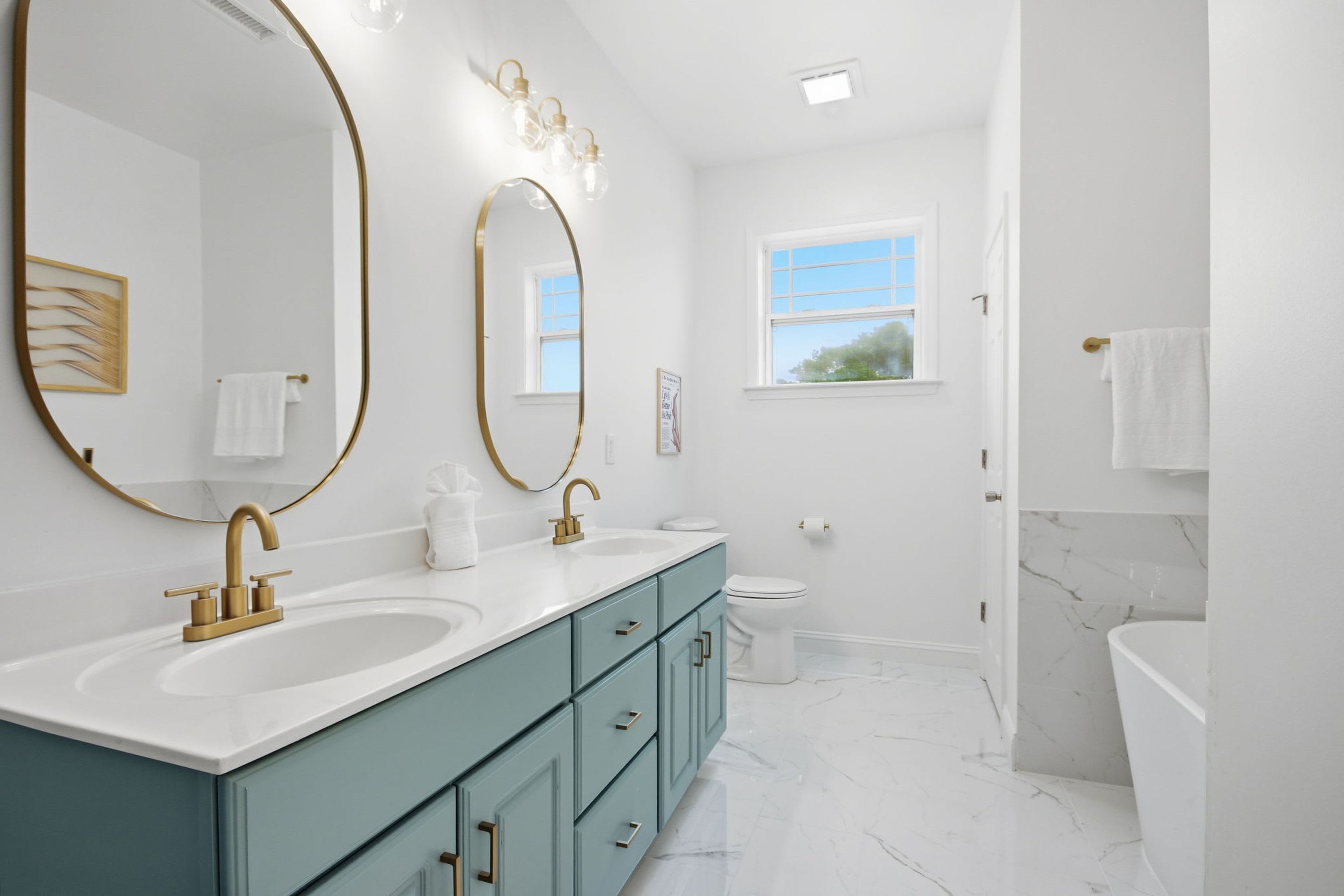 A modern bathroom with two sinks, a toilet, and a shower area.