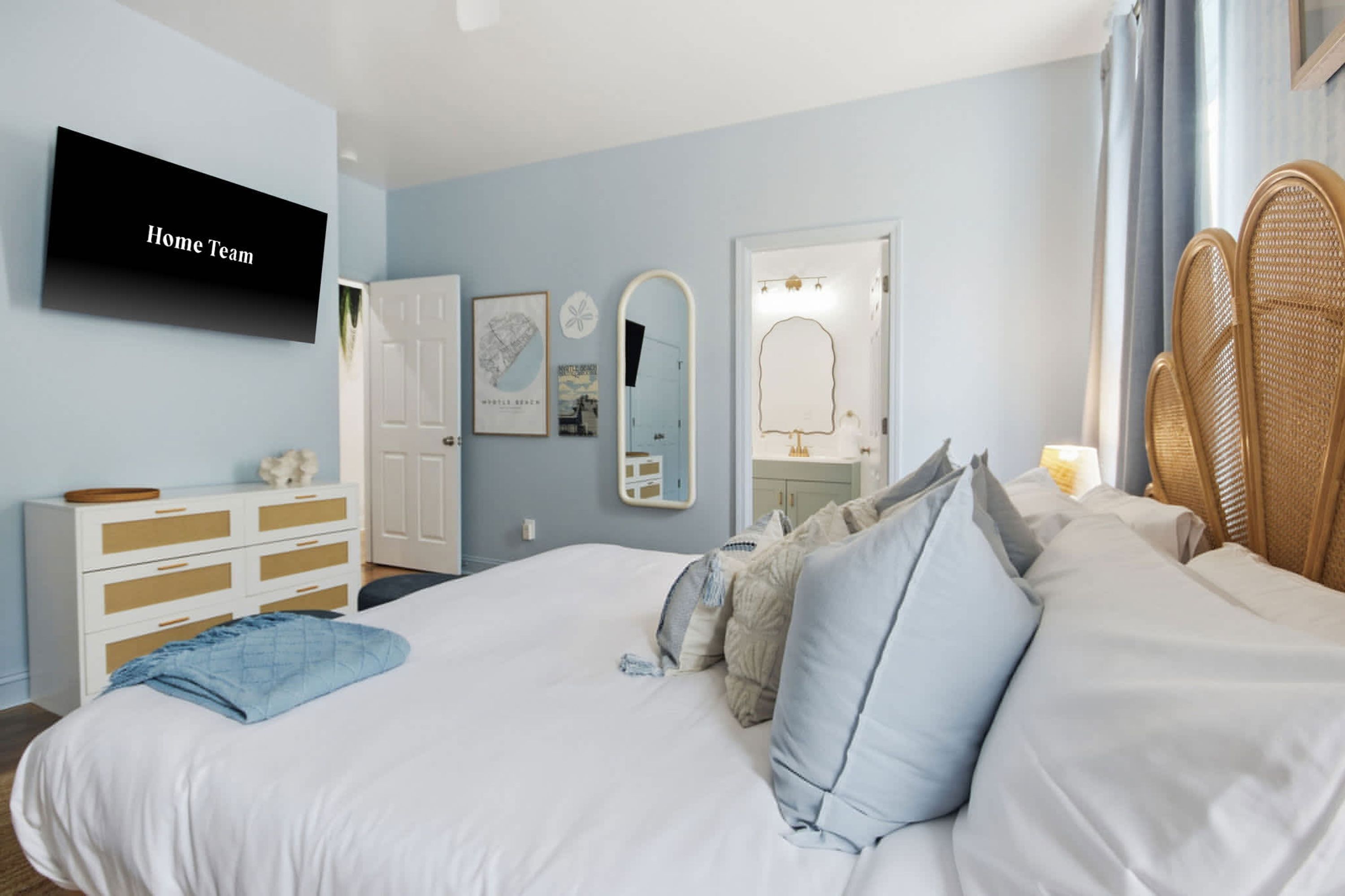 Un dormitorio con cama, cómoda, espejo y televisor en la pared.