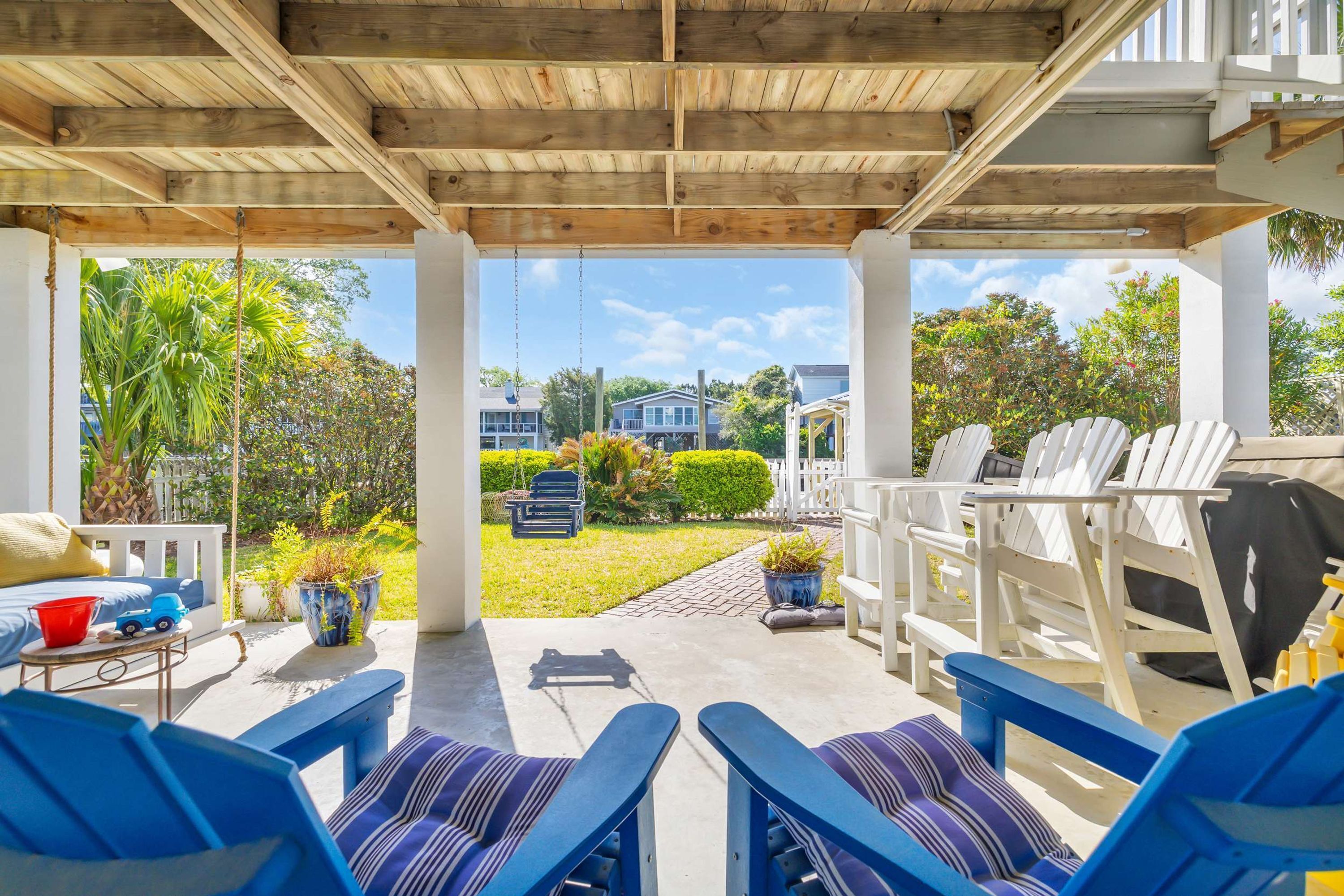 Zona d'estar a l'aire lliure coberta amb cadires blaves i un enoscador.