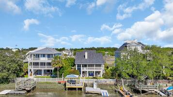 A waterfront property with multiple buildings, docked boats, and a clear sky.