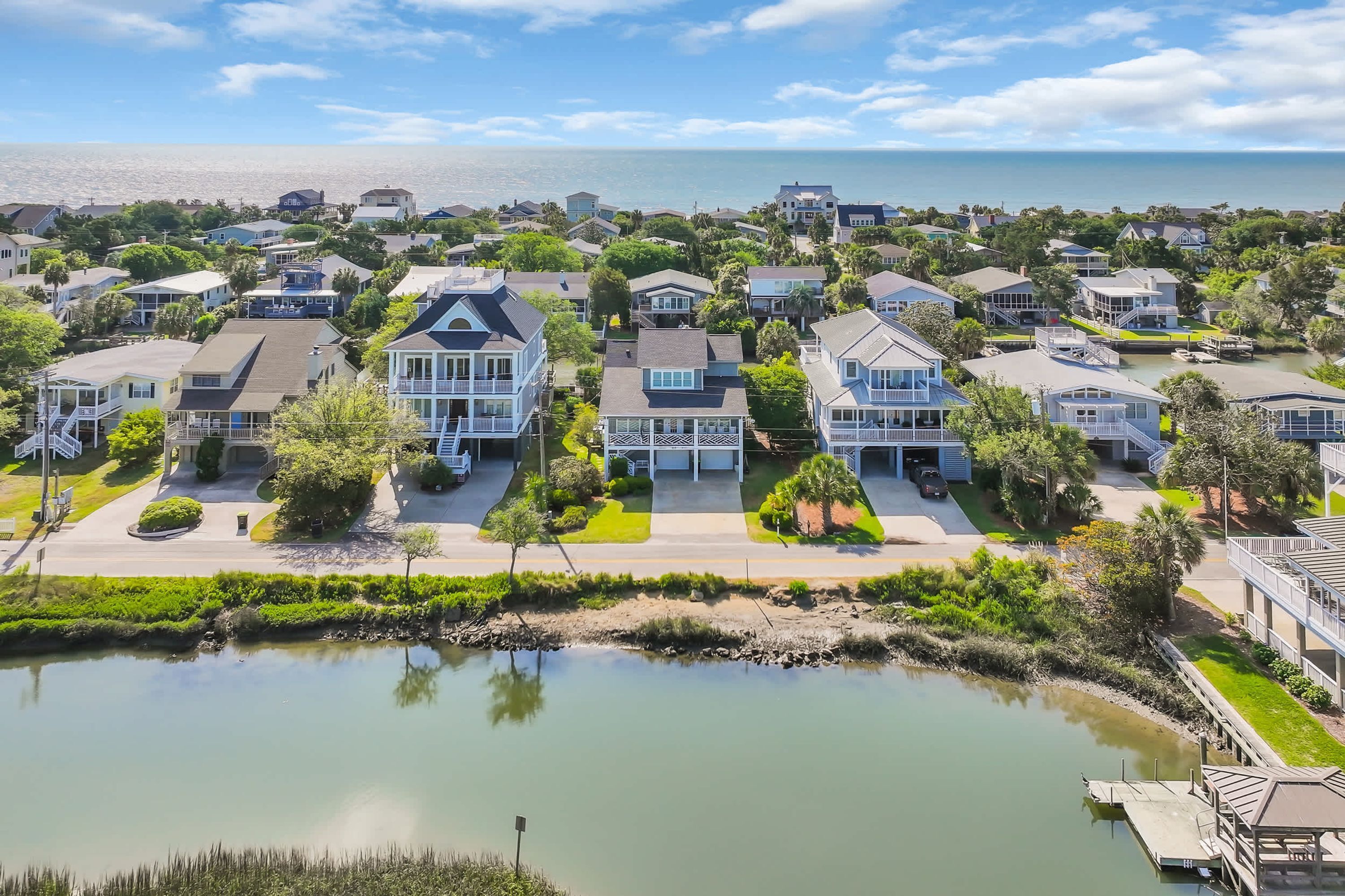 A residential area with houses, a body of water, and a clear sky.