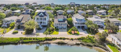 A residential area with houses, a body of water, and a clear sky.