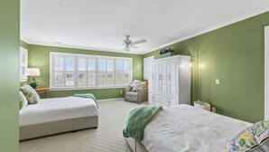 Un dormitorio con dos camas, ventilador de techo, ventana con persianas y armario.