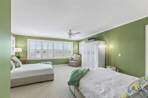 Ein Schlafzimmer mit zwei Betten, einem Deckenventilator, einem Fenster mit Jalousien und einem Kleiderschrank.