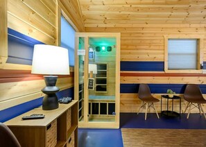 A wooden cabin interior with a desk, lamp, chairs, and a small table with a plant. - Retro Retreat Stargazing Dome Sauna Hot Tub (Broken Bow)