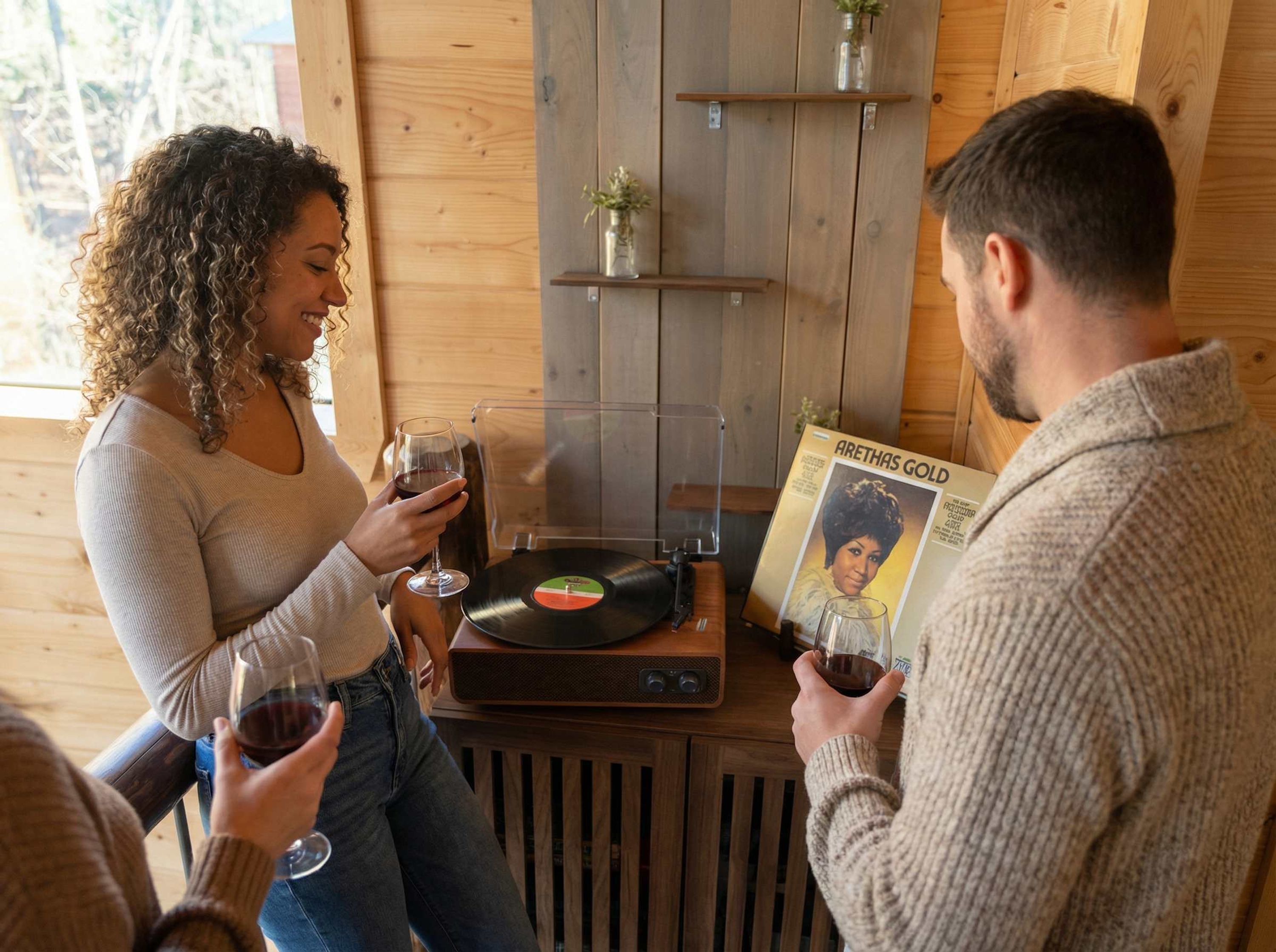 Un intérieur en bois avec une platine, un disque vinyle et un magazine intitulé « ARETHAS GOLD » posés sur une table.