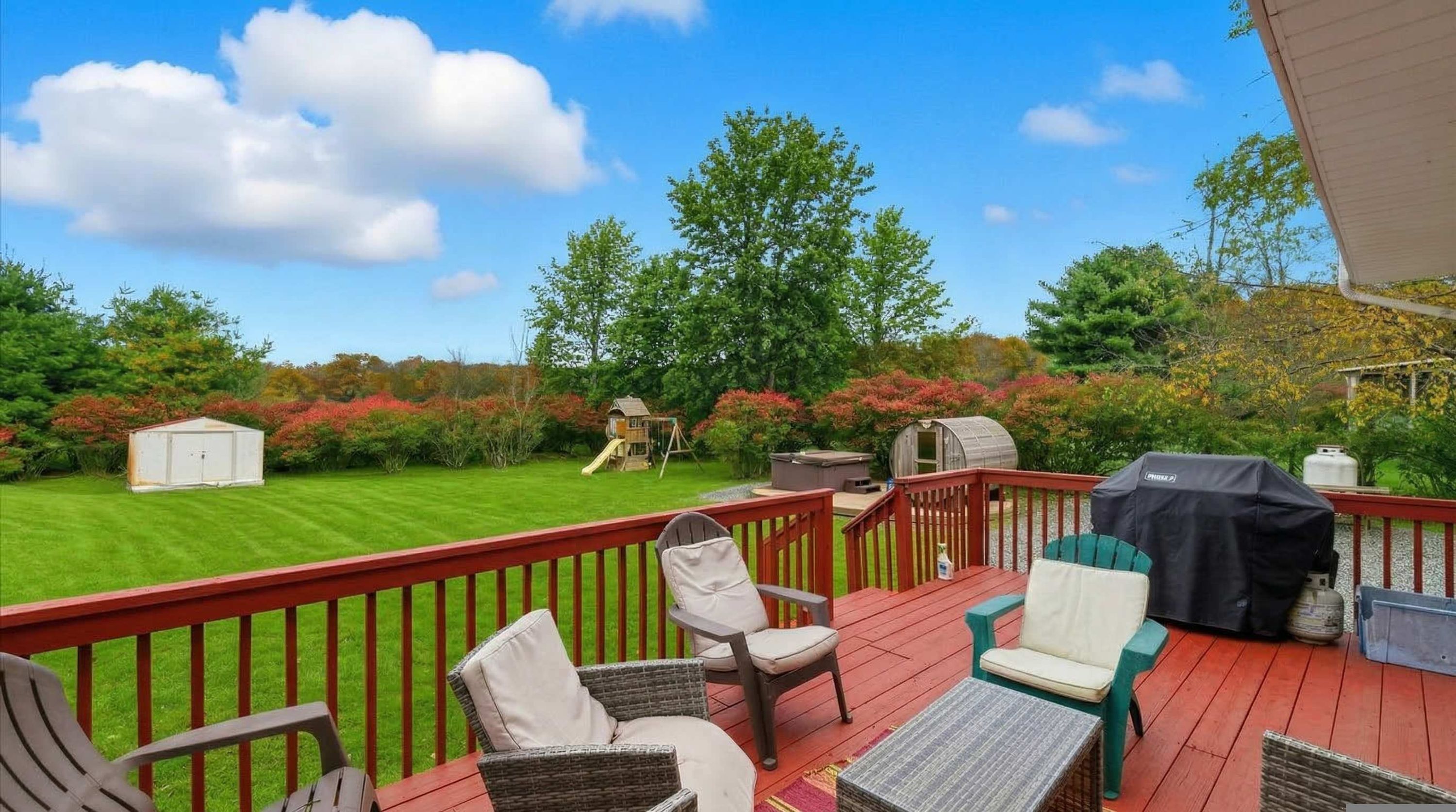 Eine Terrasse mit Gartenmöbeln, einem Grill und einem Whirlpool.