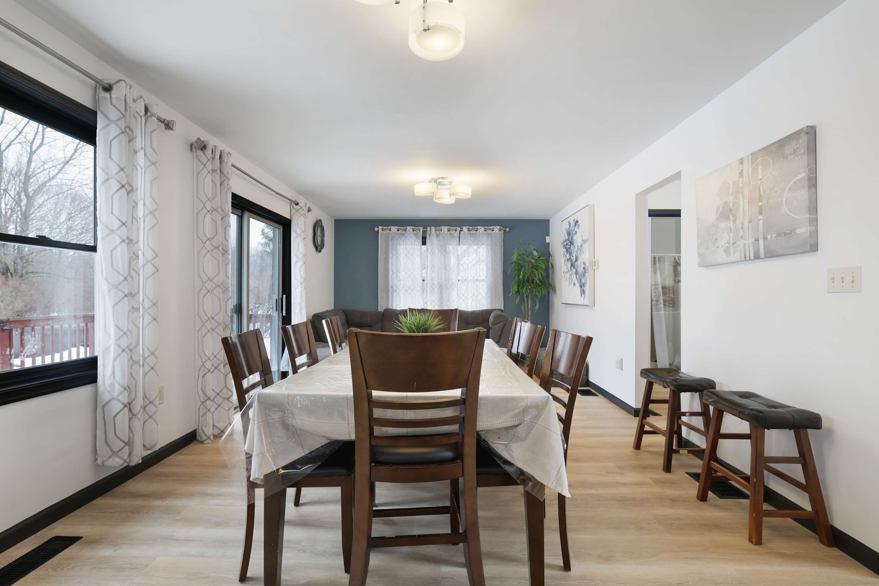Un comedor con una mesa larga, sillas y una lámpara en el techo.