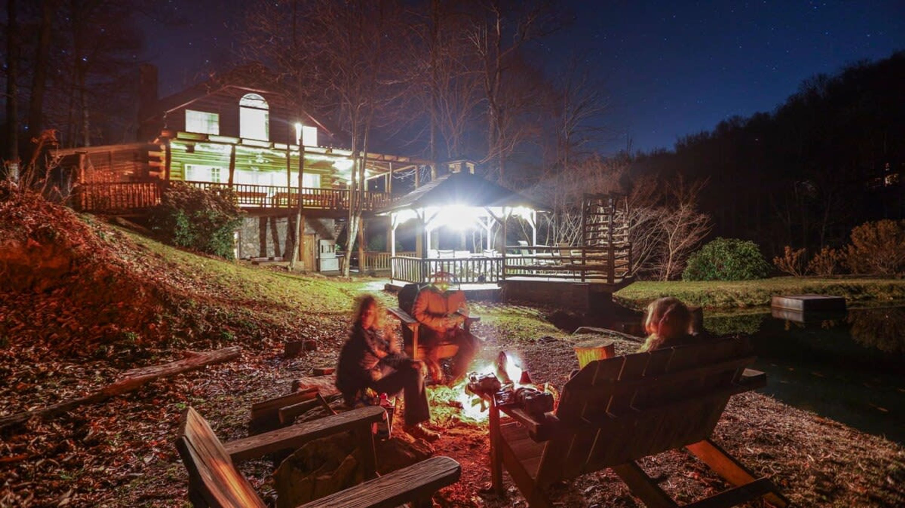 A cabin with a deck and a fire pit area.
