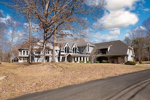 A large, two-story house with a prominent front porch and multiple windows. - Sleeps 29 Pool Tiki Bar Hot Tub Gym Dogs Welcome (McDonald)
