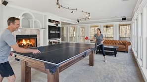 A ping pong table in a living room with a fireplace, a TV, and a sofa. - Sleeps 29 Pool Tiki Bar Hot Tub Gym Dogs Welcome (McDonald)