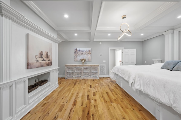A bedroom with a large bed, a dresser, and a painting on the wall. - Sleeps 29 Pool Tiki Bar Hot Tub Gym Dogs Welcome (McDonald)