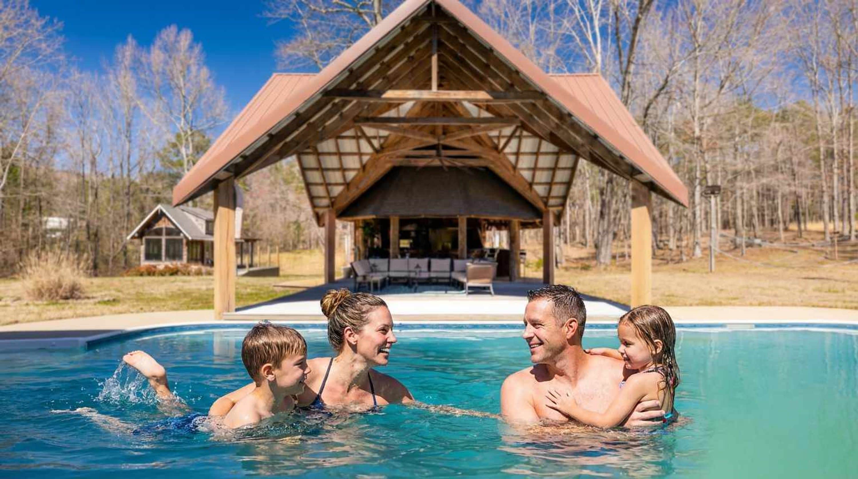 A swimming pool with a wooden pavilion in the background.
