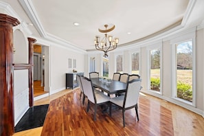 A spacious dining room with a large wooden table, six chairs, and a chandelier. - Sleeps 29 Pool Tiki Bar Hot Tub Gym Dogs Welcome (McDonald)