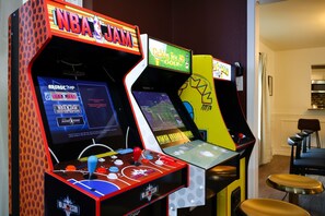 Eine Spielhalle mit mehreren Basketball-Automaten, darunter NBA JAM und weitere Sportspiele.