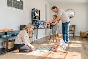 A family playing board games in a room with a Star Wars themed display and a Star Wars poster. - Sleeps 14 Outdoor Patio Firepit Game Room (Fort Walton Beach)