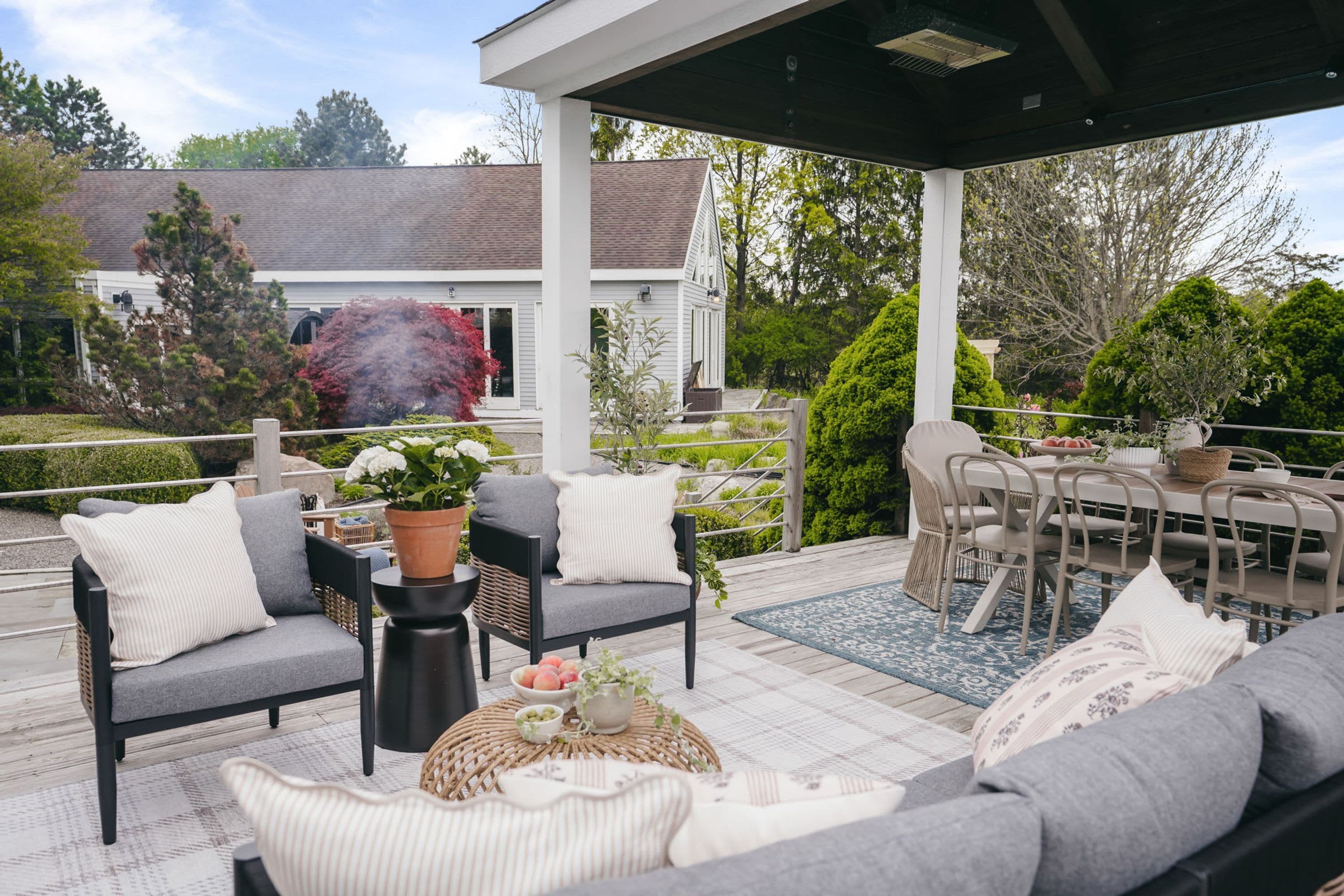 A covered outdoor seating area with a sofa, chairs, and a table.