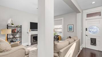 A living room with a fireplace, sofa, and television.
