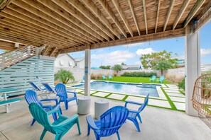A covered outdoor area with a pool, lounge chairs, and a staircase leading to a house. - Glory Daze Private Pool Ice Maker EV Charger (Port Aransas)