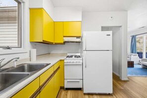 A modern kitchen with yellow cabinets, a white refrigerator, and a stove. - Sleeps 20 Sport Court Game Room Sauna Spa (Asheville)