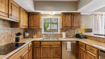 Una cocina con armarios de madera, un lavaplatos de acero inoxidable y un lavavajillas.