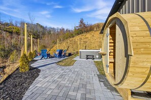 A wooden cabin with a circular door, a paved pathway, and outdoor seating. - Bryson City Cabin Sauna Hot Tub (Bryson City)