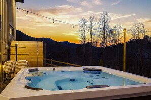 A hot tub with a view of a sunset and bare trees. - Bryson City Cabin Sauna Hot Tub (Bryson City)