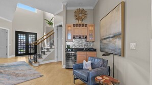 Un interior moderno con una escalera, cocina y área de descanso.