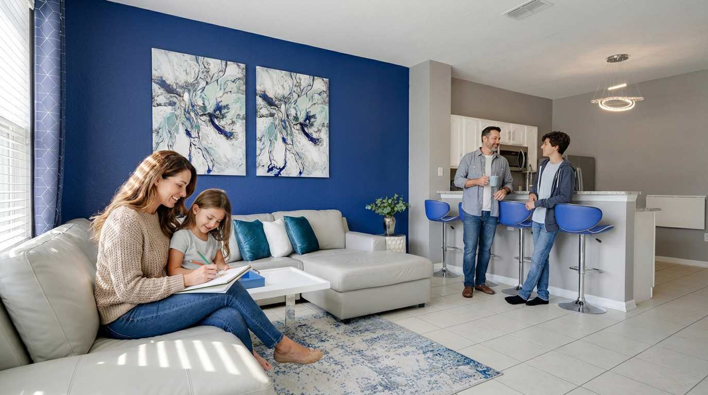 Un salon moderne avec un canapé blanc, un mur d’accent bleu et des œuvres d’art abstraites.