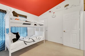 Ein Schlafraum mit Etagenbetten, einer Tür und einer Wand mit schlichtem Design.