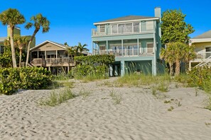 A beachfront property with a two-story building featuring balconies and a covered porch. - Walks on the Shores Private Beach Front Access (Indian Shores)