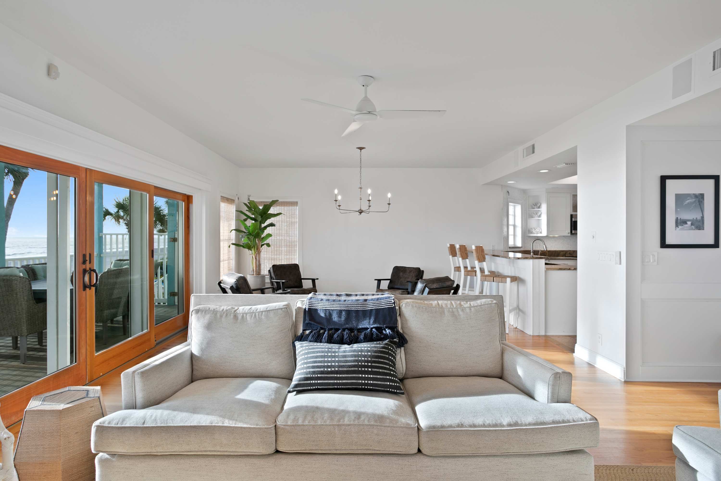 A modern living room with a sofa, a dining area, and a kitchen.