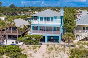 A two-story beachfront house with a balcony, surrounded by sand and vegetation. - Walks on the Shores Private Beach Front Access (Indian Shores)