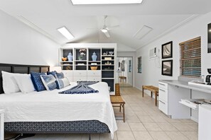 A modern bedroom with a large bed, a built-in wardrobe, a desk area, and a skylight. - Walks on the Shores Private Beach Front Access (Indian Shores)