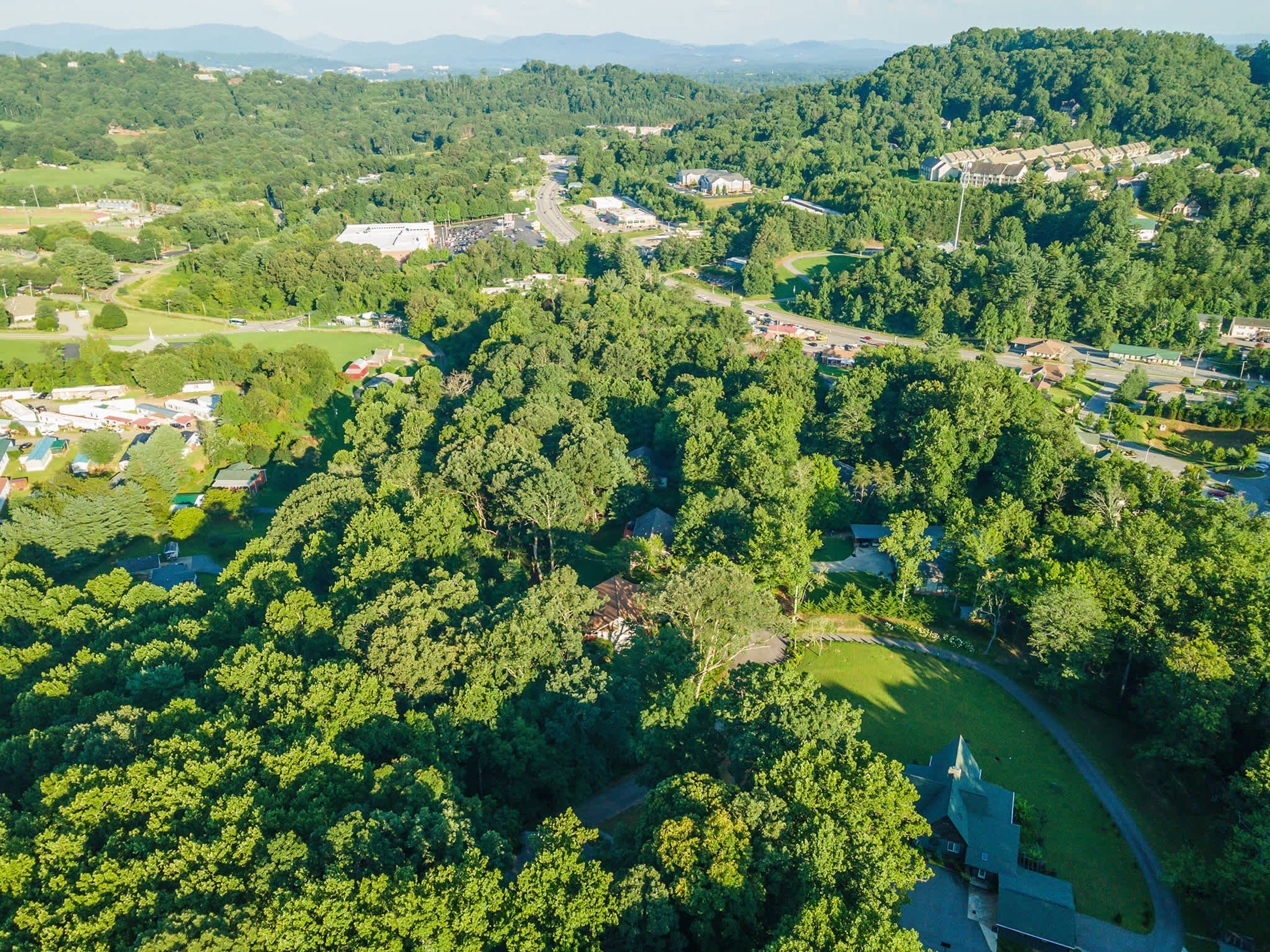 An aerial view of a residential area with houses, roads, and green spaces.