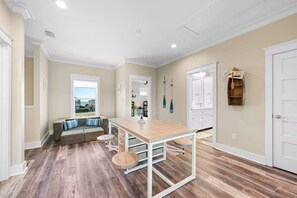 A spacious kitchen with a central island, a dining area with a bench, and a view through a window. - Waterfront Views - Walk to Beach - Heated Pool (Gulf Shores)