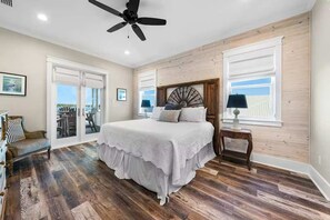 A bedroom with a large bed, a ceiling fan, and a view through a glass door. - Waterfront Views - Walk to Beach - Heated Pool (Gulf Shores)