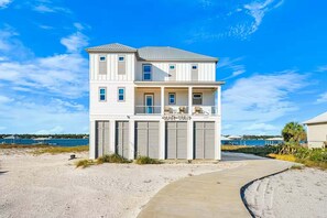 A two-story beachfront property with a covered porch and a garage. - Waterfront Views - Walk to Beach - Heated Pool (Gulf Shores)