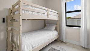 A bunk bed room with a window and curtains. - Backyard Oasis Pool Game Room Sleeps 10 (Cape Coral)