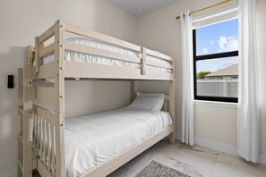 A bunk bed room with a window and curtains. - Backyard Oasis Pool Game Room Sleeps 10 (Cape Coral)