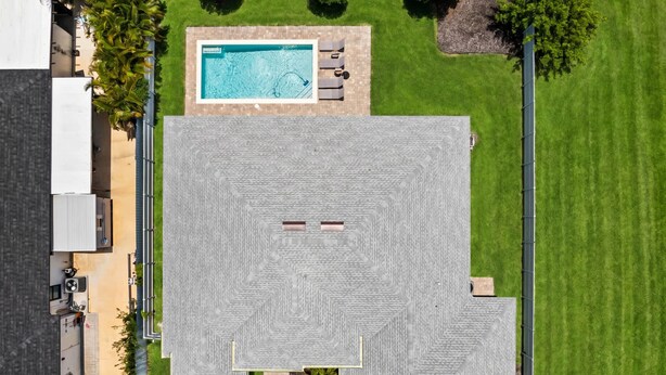 A rooftop with a swimming pool, a covered patio area, and a well-maintained lawn. - Backyard Oasis Pool Game Room Sleeps 10 (Cape Coral)