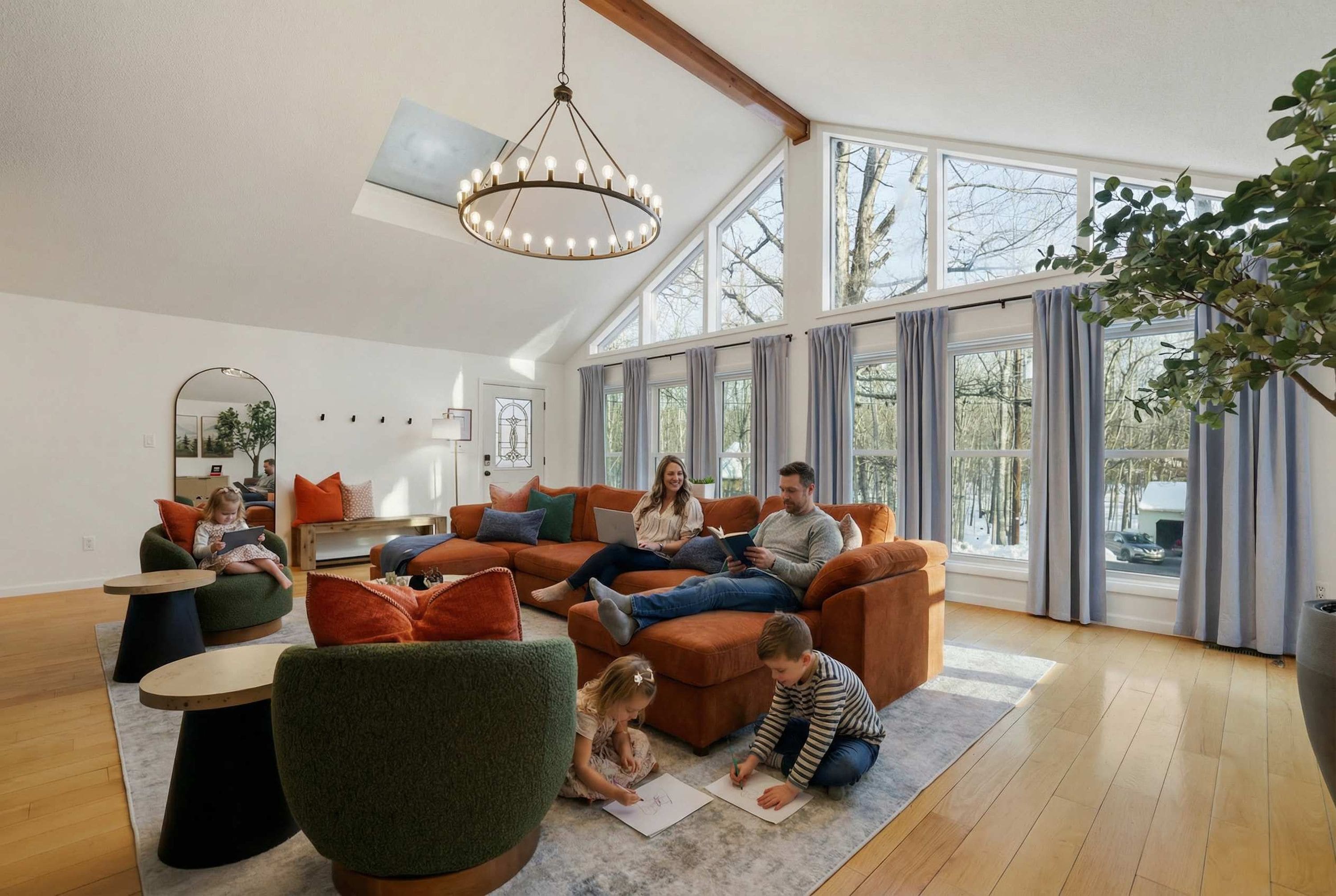 Un salón amplio con techo alto, ventanas grandes y una lámpara moderna.