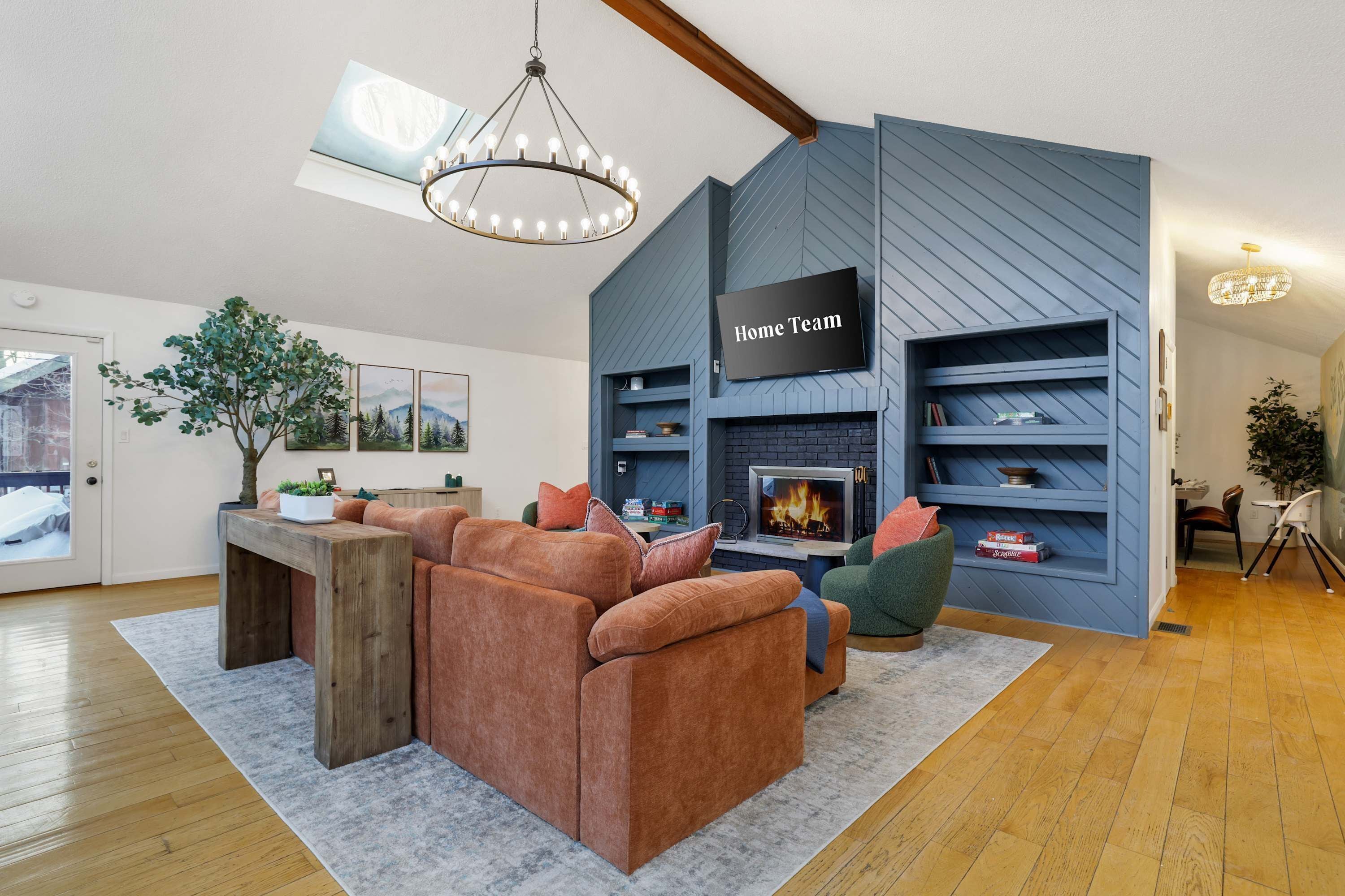 A modern living room with a sectional sofa, a fireplace, and a mounted TV.