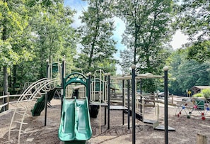A playground with various equipment including slides and climbing structures. - The Ridge at Penn Estates A 4BR Pocono Retreat (East Stroudsburg)