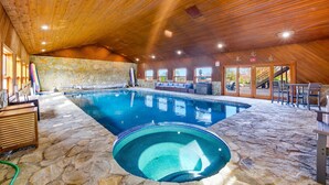 An indoor swimming pool with stone flooring, wooden ceiling, and seating areas. - Lake Mathews Estate Indoor Pool Pickleball Beach Volleyball (Perris)