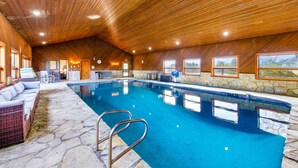 An indoor swimming pool with stone flooring, wooden ceiling, and a seating area with cushions. - Lake Mathews Estate Indoor Pool Pickleball Beach Volleyball (Perris)