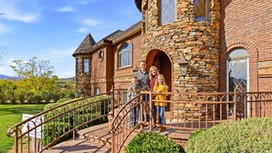 A stone building with a staircase leading to a gated entrance. - Lake Mathews Estate Indoor Pool Pickleball Beach Volleyball (Perris)