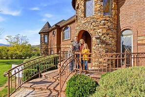 A stone building with a staircase leading to a gated entrance. - Lake Mathews Estate Indoor Pool Pickleball Beach Volleyball (Perris)