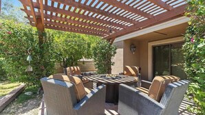 An outdoor patio with wicker furniture, a pergola, and a fire pit. - Waz-4901 E Sunnyside Dr (Scottsdale)